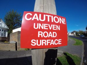 CAUTION! UNEVEN ROAD SURFACE, Sign